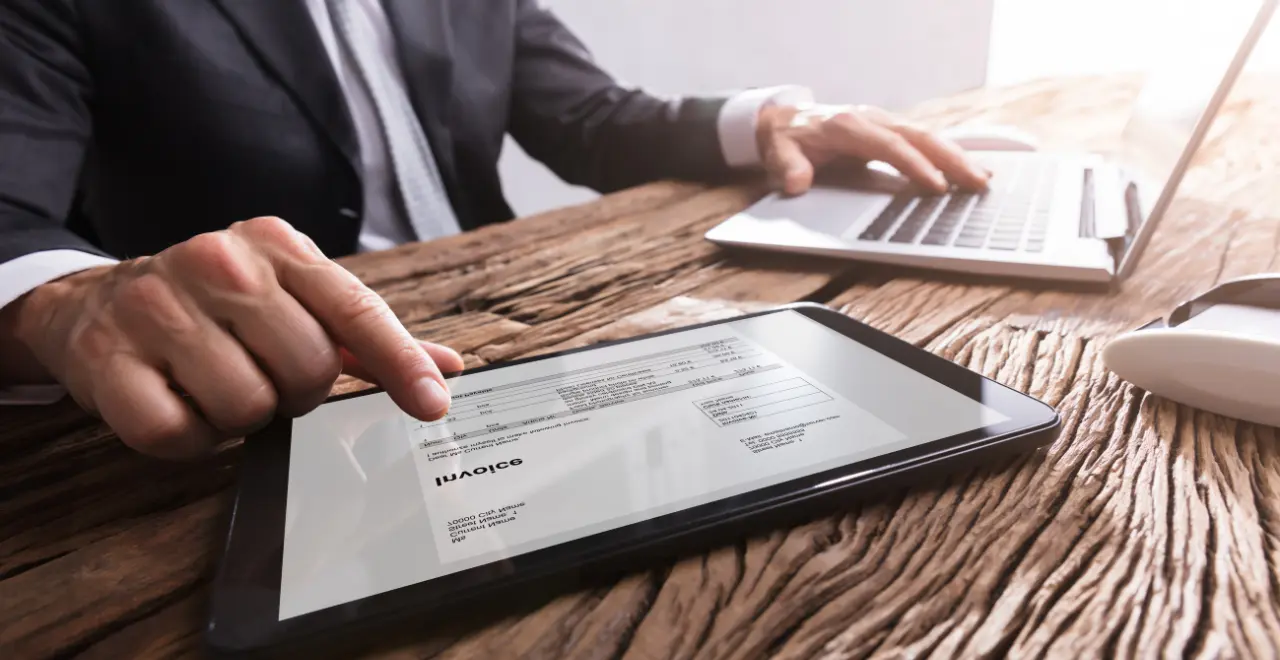 mains-homme-travaillant-une-facture-sur-tablette Facture électronique sur une tablette