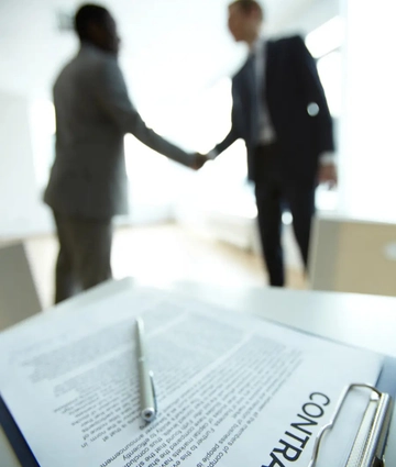 Illustration d'un contrat signé et d'une poignée de main